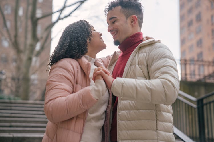 Cheerful Hispanic Couple Hugging On Street