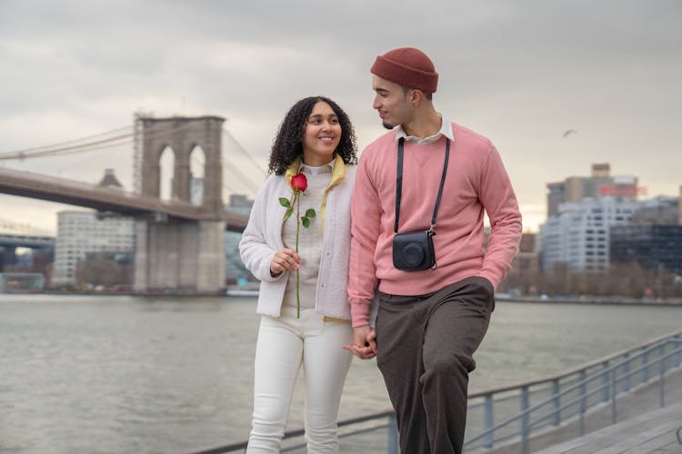 Cheerful Hispanic Couple Walking On Embankment