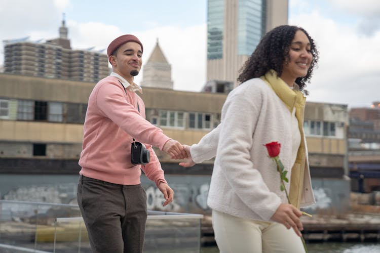 Smiling Hispanic Couple Holding Hands During Date