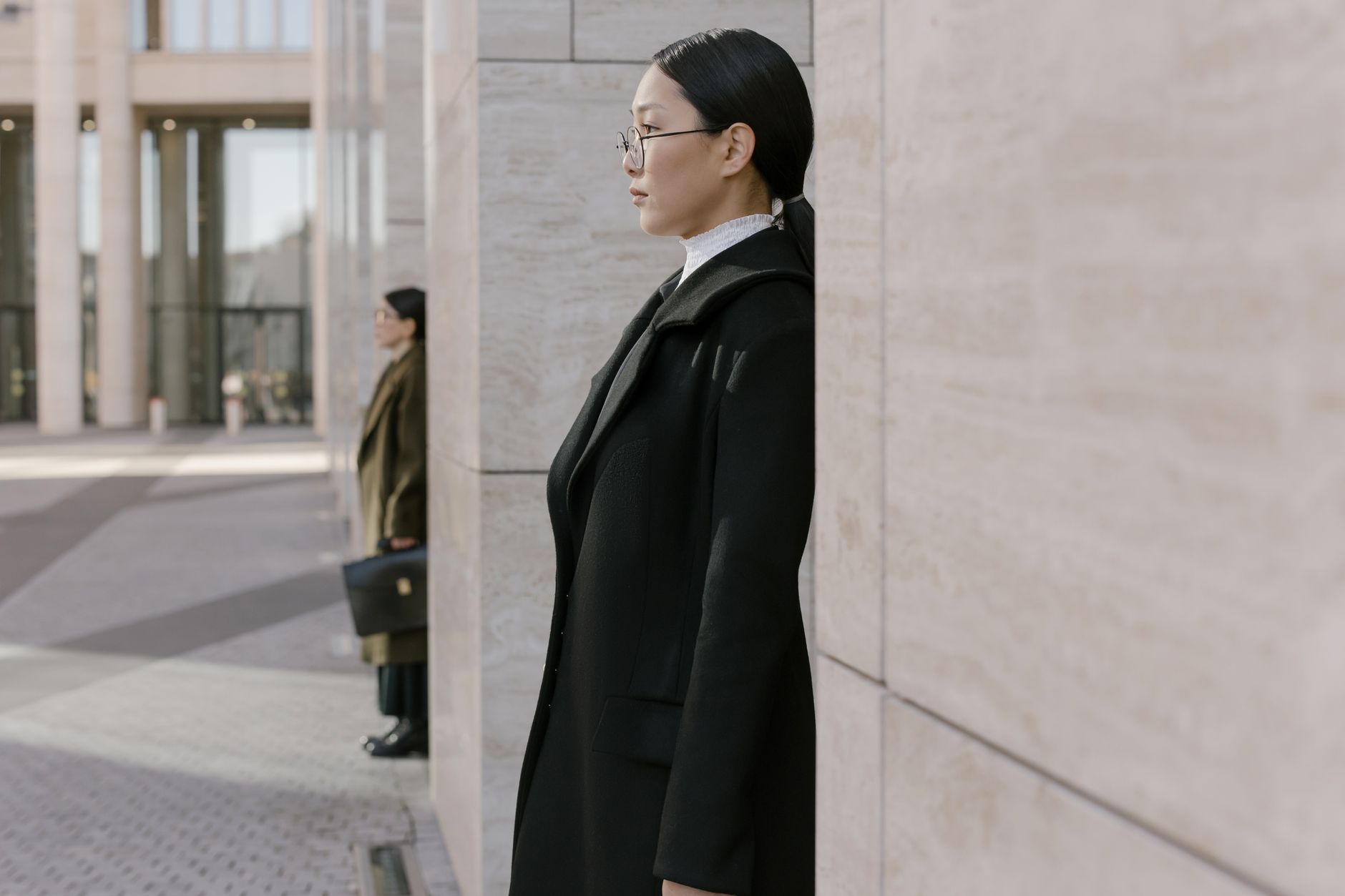 Profile of an elegant businesswoman in a modern urban environment.