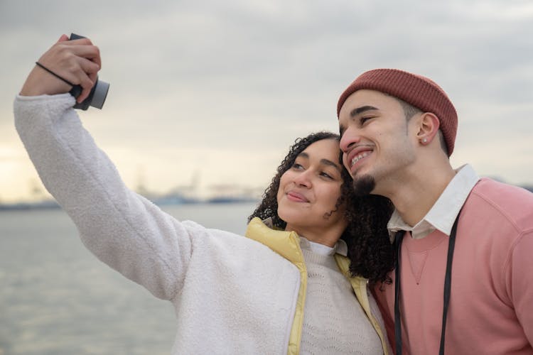 Hispanic Couple Taking Self Photo On Film Camera Near River