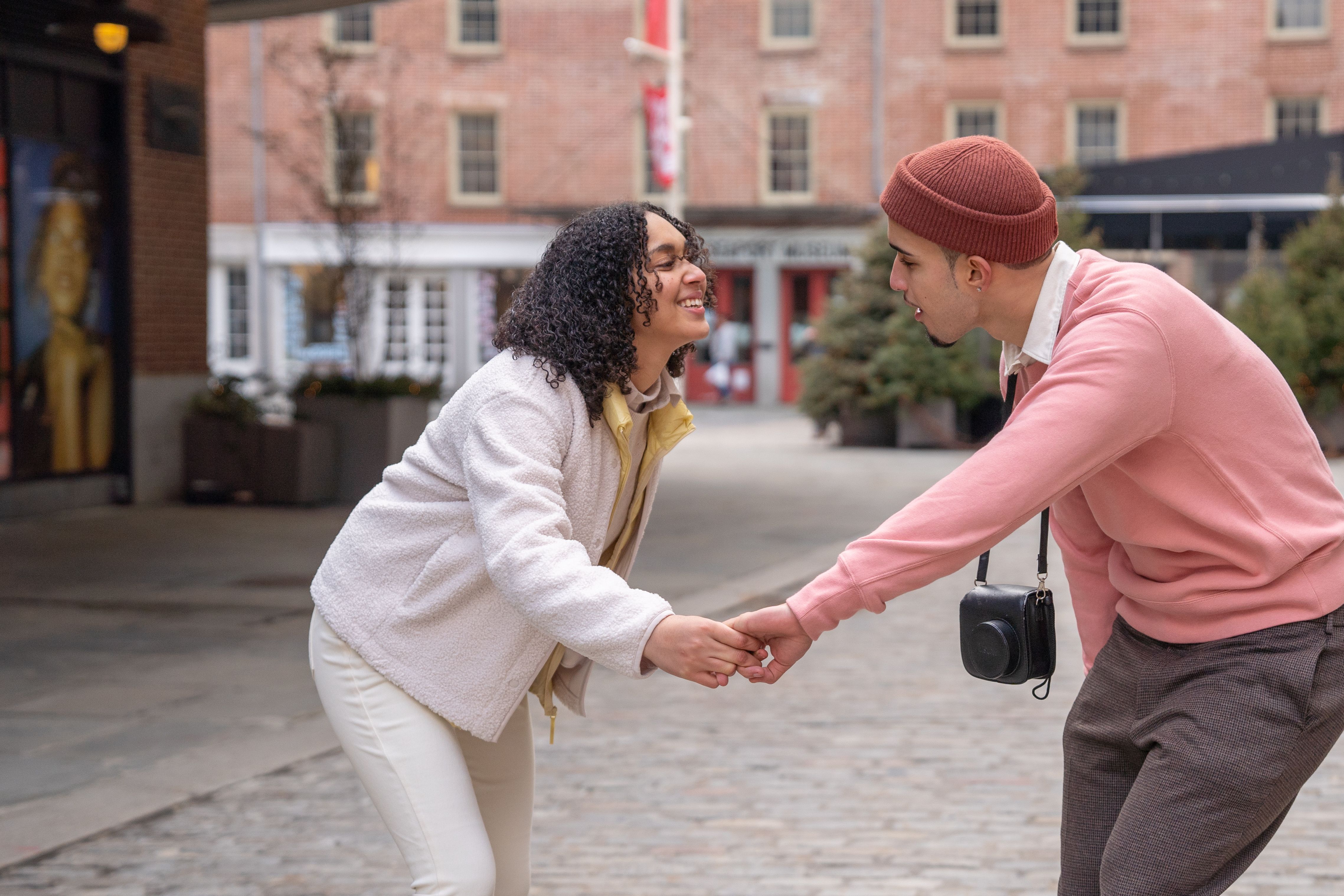 Young couple dancing on a city street, smiling — stock photo