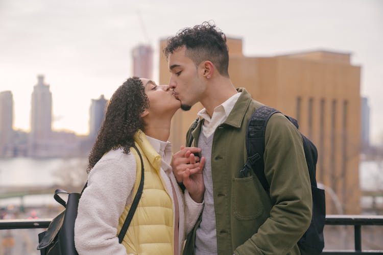 Loving Hispanic Couple Kissing On Street