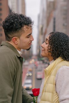 Side view of ethnic boyfriend and crop girlfriend looking at each other on blurred background of road