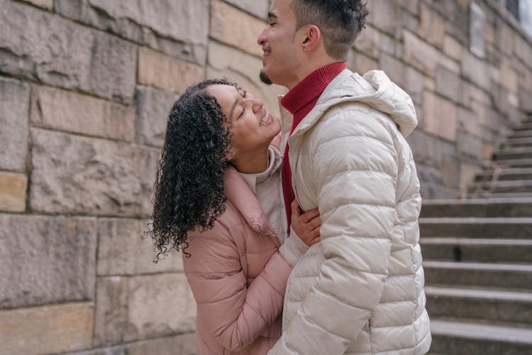 Cheerful Hispanic Couple Embracing Near Steps