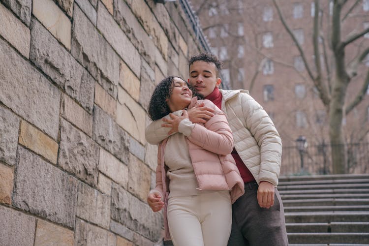 Loving Young Hispanic Couple Embracing On Street