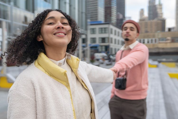 Cheerful Hispanic Couple With Photo Camera Holding Hands