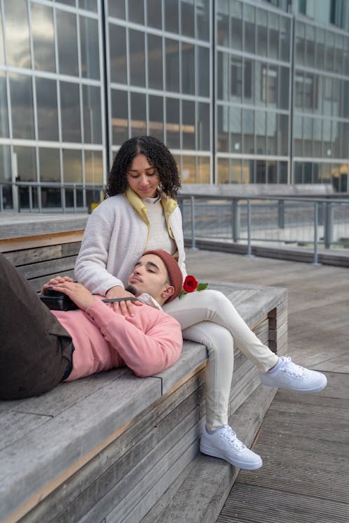 Free Loving young Hispanic couple relaxing on bench in city Stock Photo