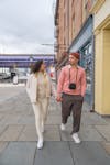 Free Trendy young ethnic couple holding hands while walking along street Stock Photo