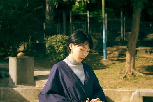 Portrait of a woman outdoors in a peaceful park setting, enjoying a sunny day.