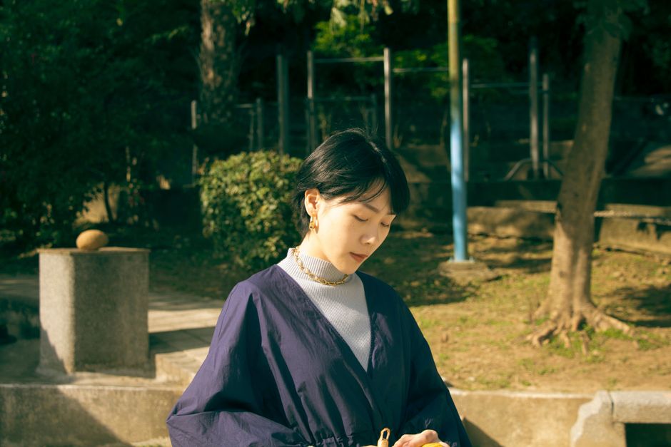 Portrait of a woman outdoors in a peaceful park setting, enjoying a sunny day.
