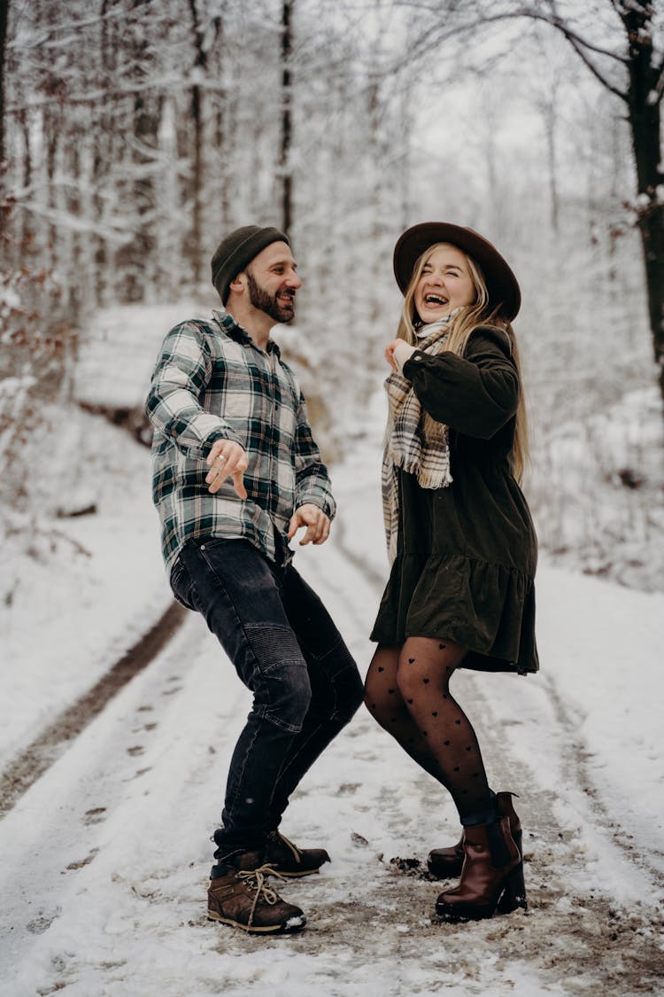 A Couple Dancing In The Middle Of A Snow Covered Road