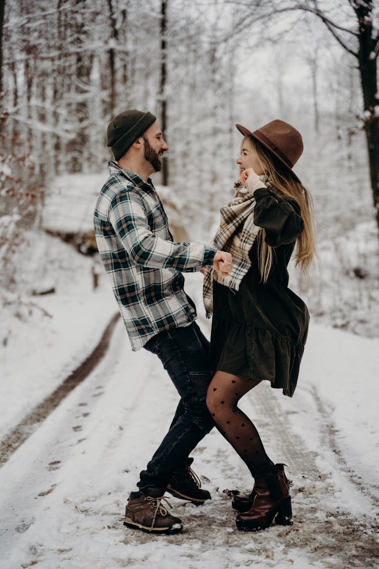 A Couple Dancing In The Middle Of A Snow Covered Road