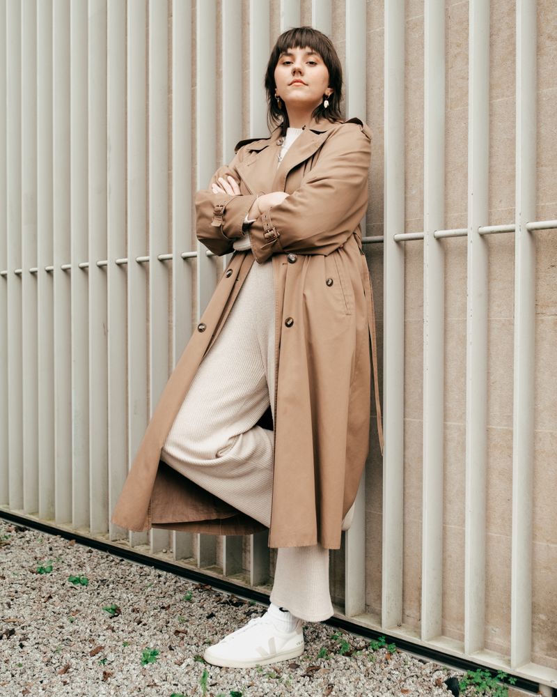 woman in camel trench coat with cream monochrome outfit