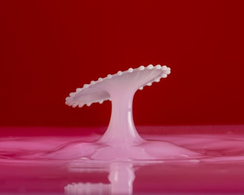 A White Pedestal Figurine Melting on a Pink Liquid