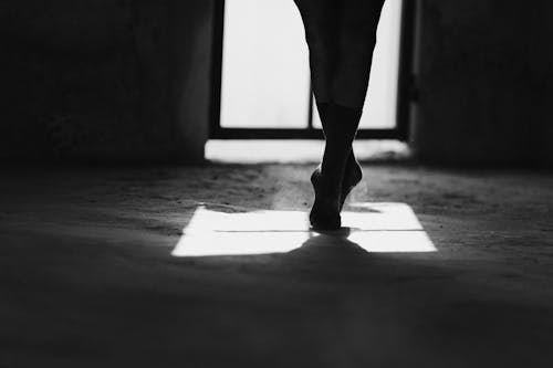 Free Faceless ballet artist standing on tiptoes on floor in sunlight Stock Photo