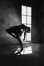 Graceful ballerina dancing in house with shadow on floor
