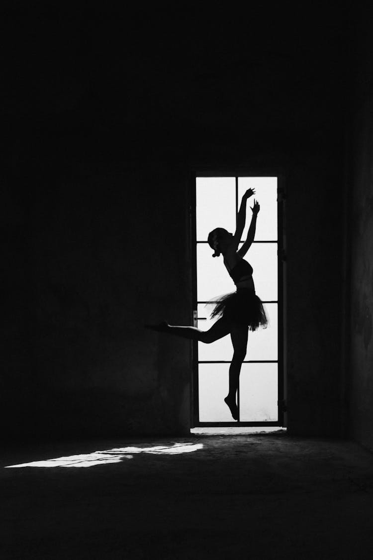 Unrecognizable Ballerina Silhouette Jumping With Raised Arms