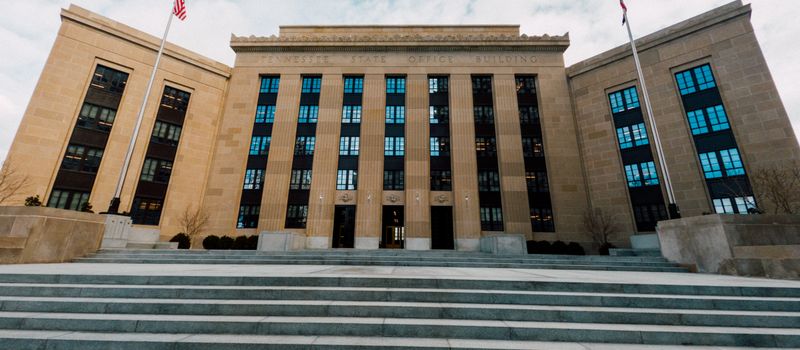 米連邦準備制度理事会の建物と国旗を望む情景。金融政策の行方に注目が集まる中、FRBの存在感を示すイメージ。