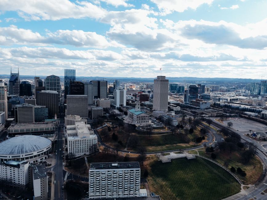 Breathtaking Nashville Helicopter Tour: Quick Hop Review — Your Aerial Adventure Over Music City Review 2026 - Drone view of modern multistory building exteriors and trees under cloudy sky in town