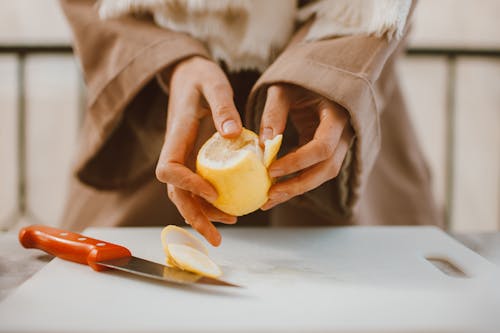 A Person Peeling a Lemon
