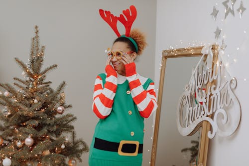 A Woman in Ugly Christmas Sweater Putting On a Christmas Eyewear