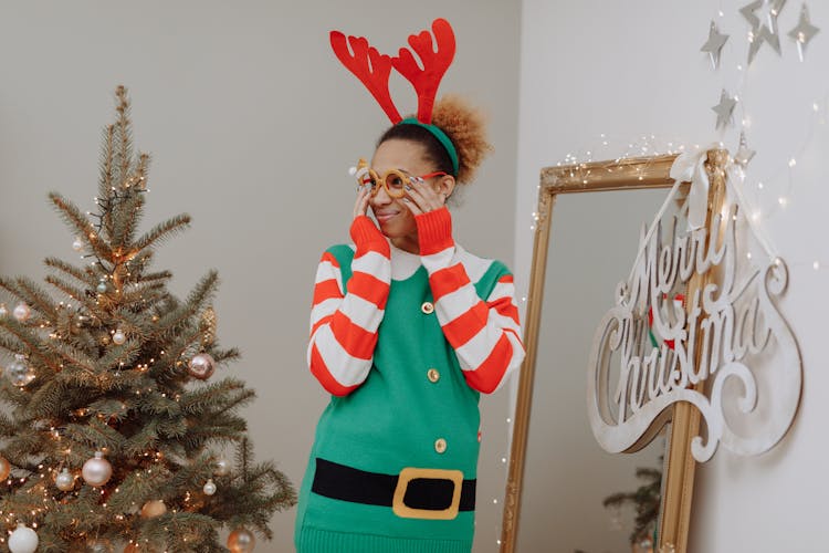 A Woman In Ugly Christmas Sweater Putting On A Christmas Eyewear