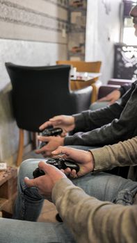 Three people engaged in a video game session indoors holding game controllers.