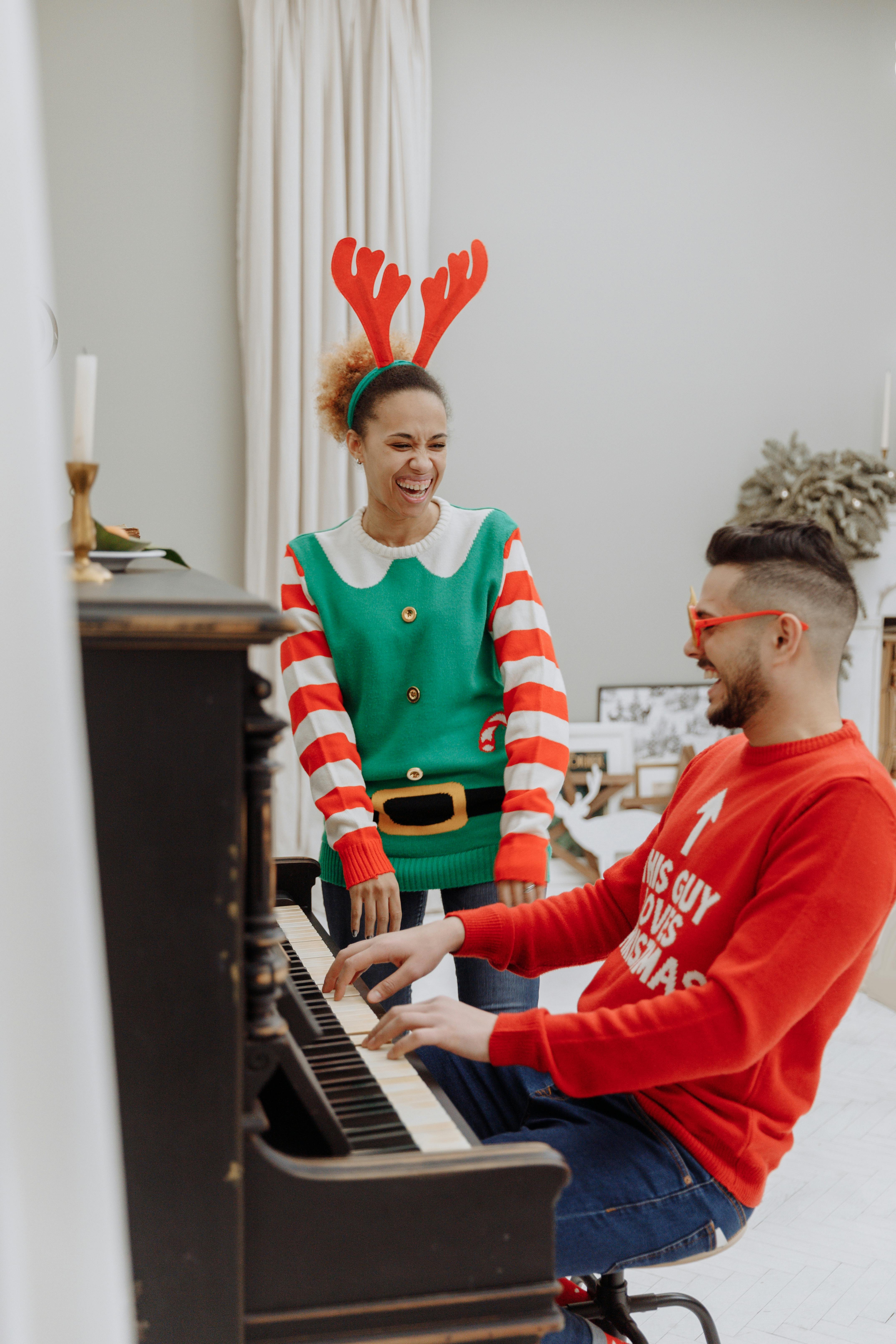 a couple laughing while playing the piano