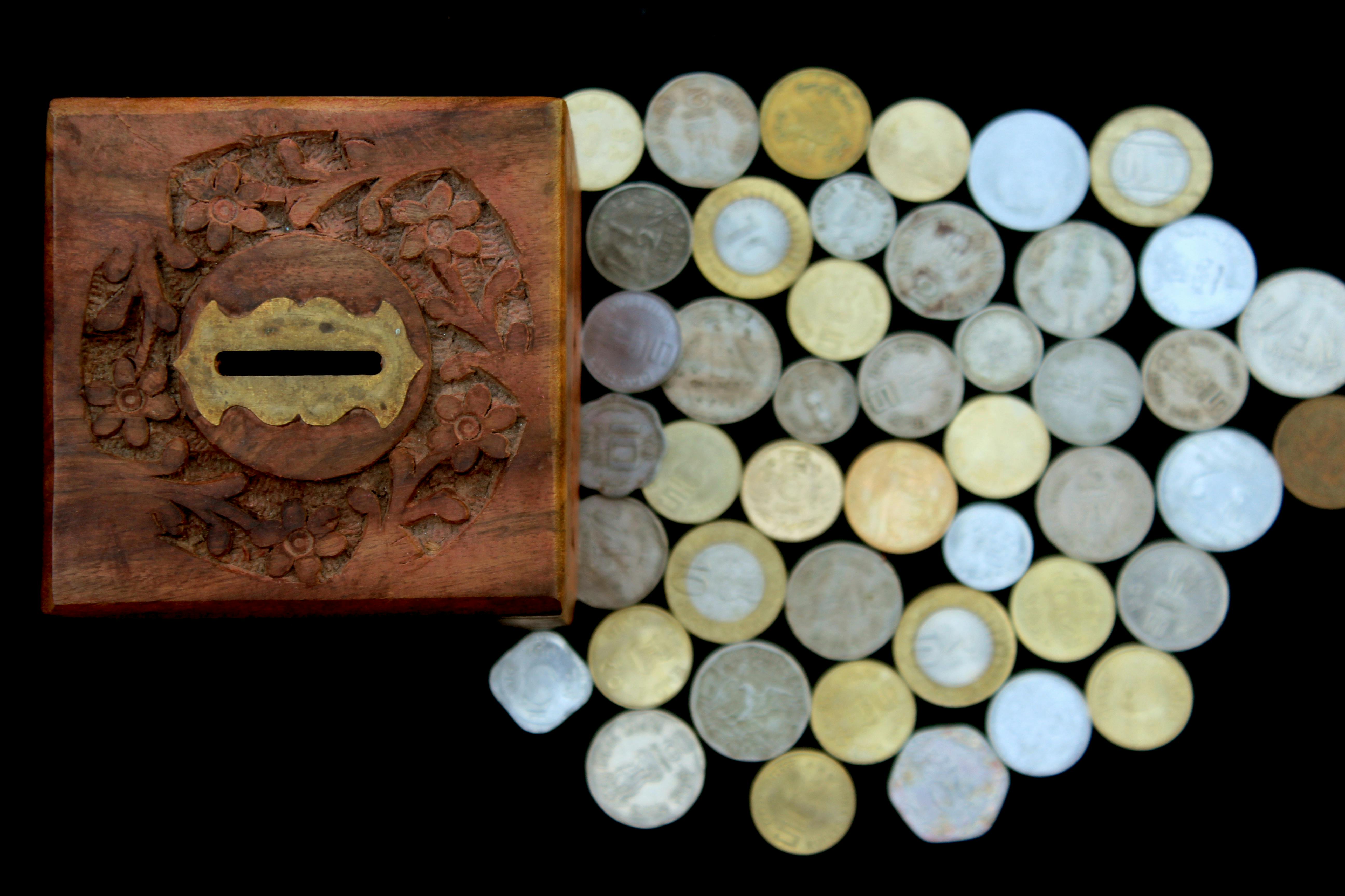 brown wooden box beside silver round coins