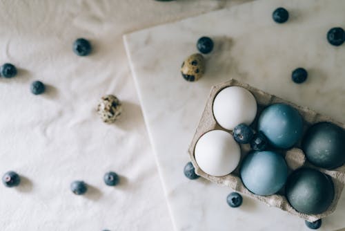 Blue Colored Eggs And White Eggs On Marble Surface