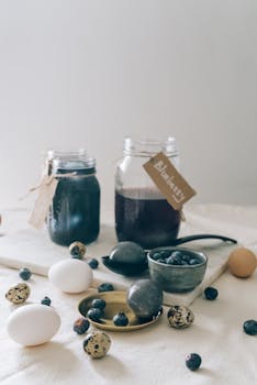 A minimalist setup of easter eggs and blueberry dye for creative Easter celebrations.