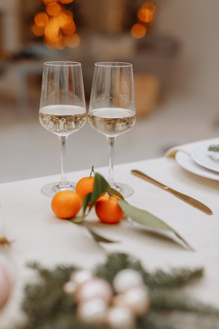 Champagne Glasses And Mandarin Oranges On The Table