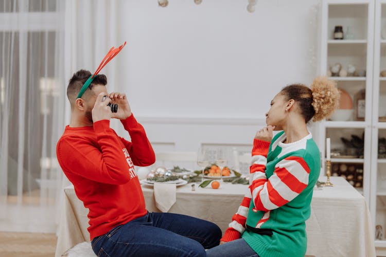 A Couple Wearing Christmas Sweaters