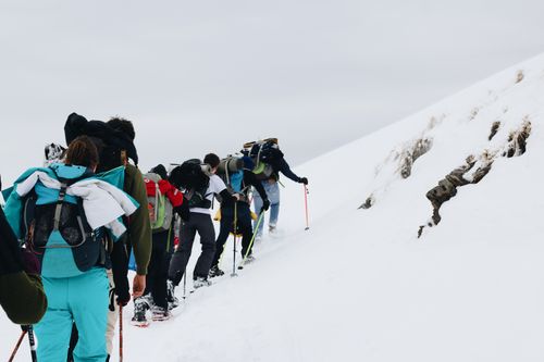 Free Adventurous group of mountaineers climbing a snowy mountain, highlighting winter exploration. Stock Photo