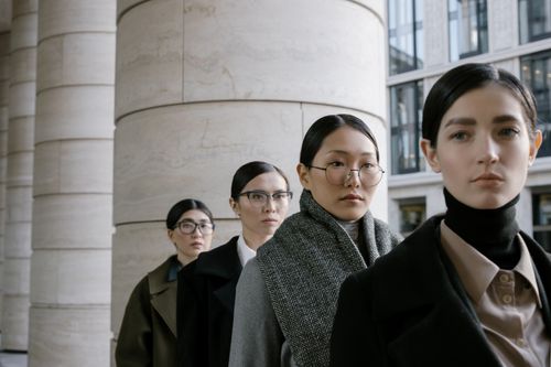Free Four diverse women in business attire stand confidently in an urban setting, showcasing modern elegance. Stock Photo