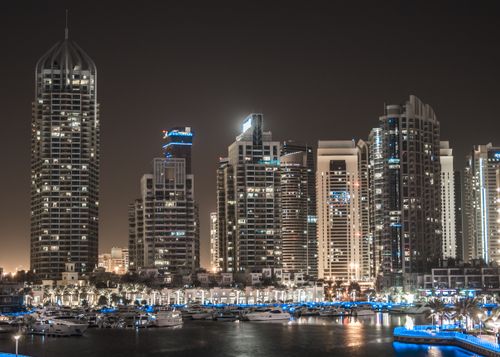 Free Illuminated view of Dubai Marina's breathtaking skyline featuring iconic skyscrapers and luxury yachts. Stock Photo