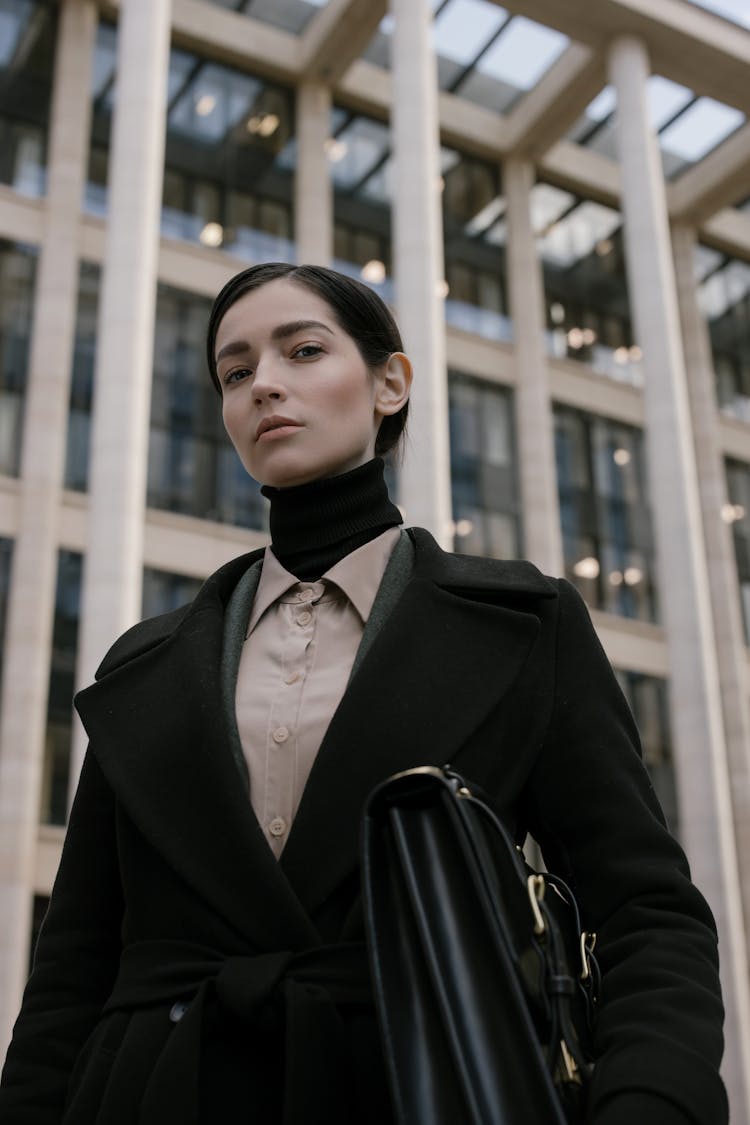 A Woman In Black Coat Carrying A Black Briefcase