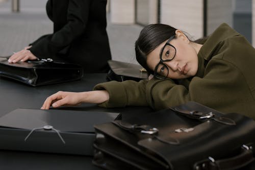 A Woman with Eyeglasses Resting her Head on the Table