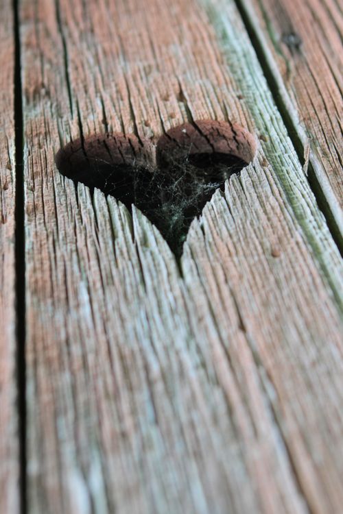 Free A heart-shaped hole in aged wood, capturing natural textures and patterns. Stock Photo