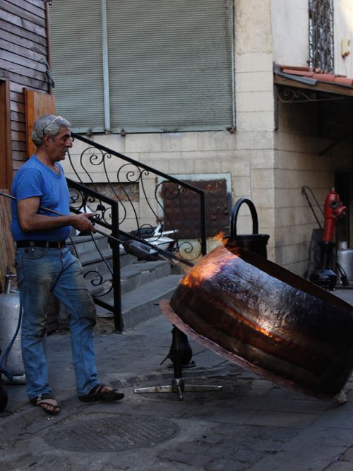 Free A craftsman uses a blow torch on a large metal pot in an outdoor Gaziantep workshop. Stock Photo