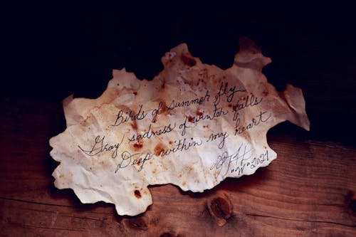 White Burnt Paper With Text On Brown Wooden Table