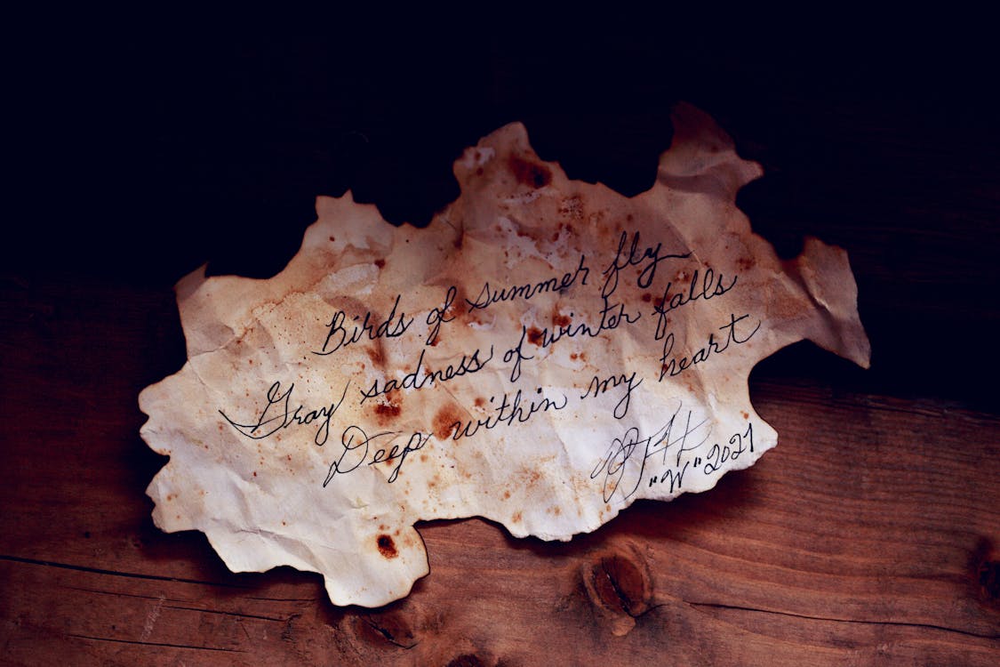 Free White Burnt Paper With Text On Brown Wooden Table Stock Photo