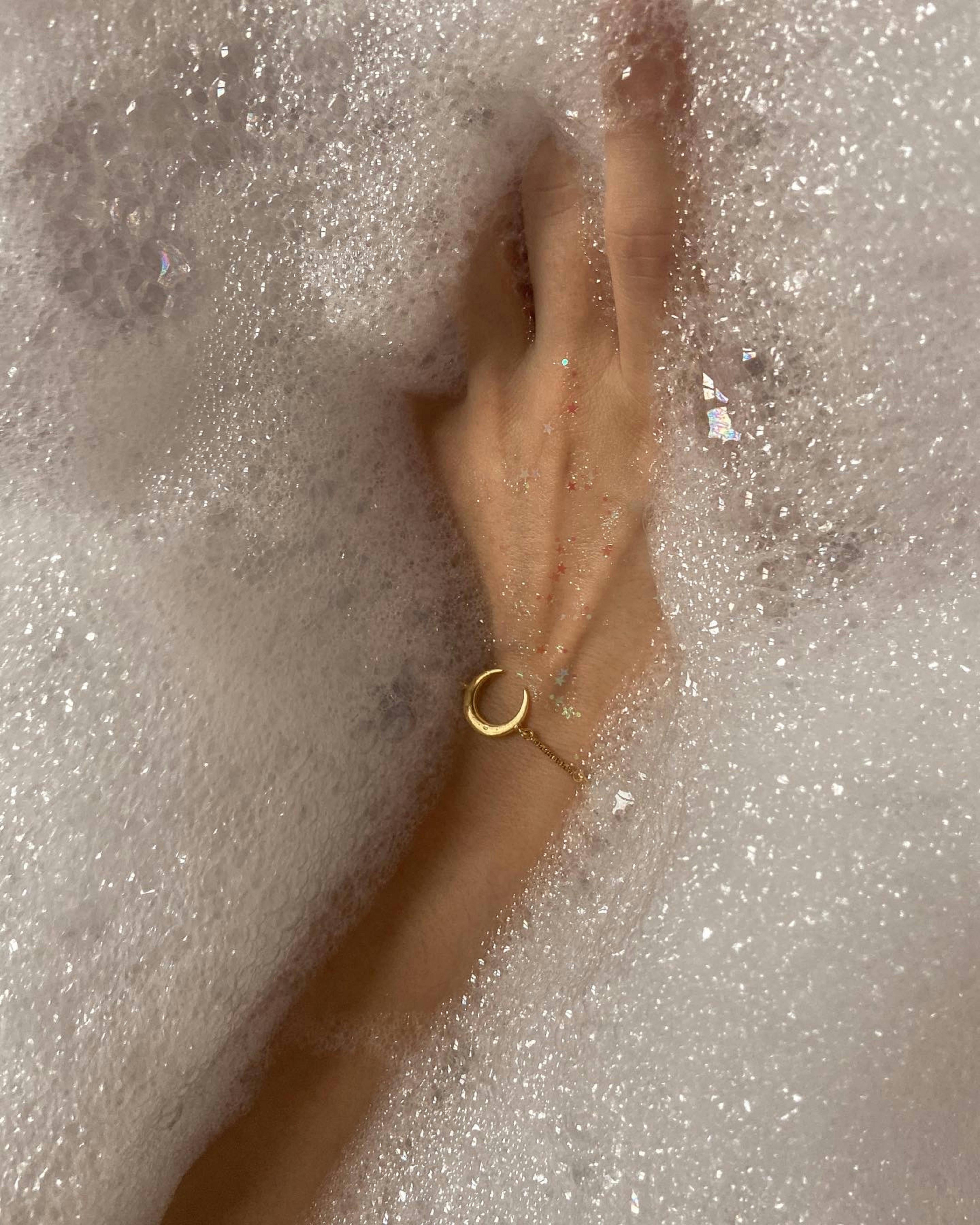 woman with bracelet taking bath with foam