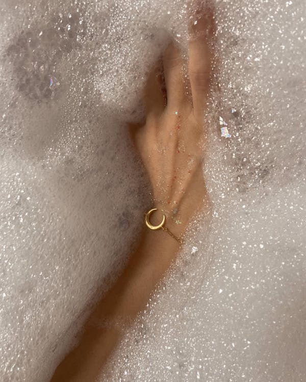 Woman with bracelet taking bath with foam