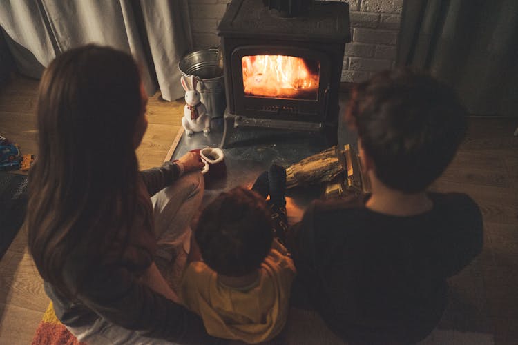 Unrecognizable Children Sitting Near Fireplace During