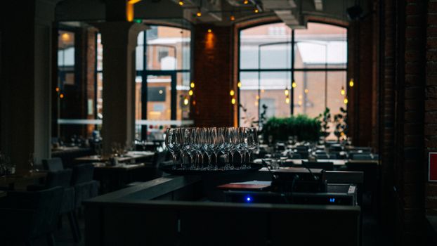 A dimly lit restaurant interior featuring a set of clean wine glasses and a cozy atmosphere.
