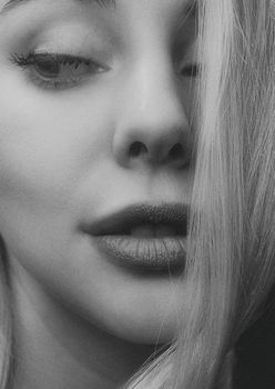 Artistic grayscale close-up of a young woman's face with subtle expression in Kyiv.