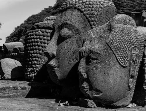 Grayscale Photo of Stone Buddha Heads