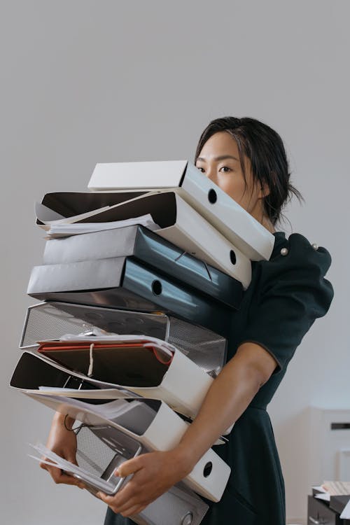 A Woman Holding a Pile of File Folders